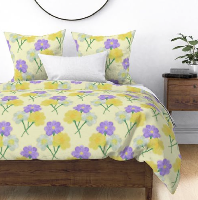 Diamond repeat pattern of three painted butter cups a yellow flower a purple flower and a white flower on duvet cover and pillow cases.